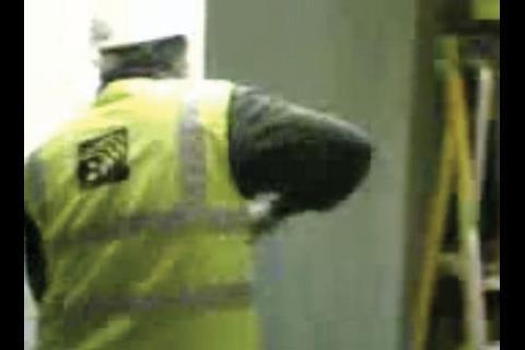 2 With the NG Bailey logo clearly displayed on his jacket, a worker ignites a colleague’s boot